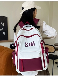 Lifestyle view showing the back fit of a large bicolor burgundy and white campus backpack