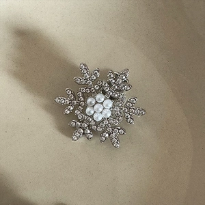 Detail view of snowflake hair clip with silver alloy, sparkling crystals and faux pearls