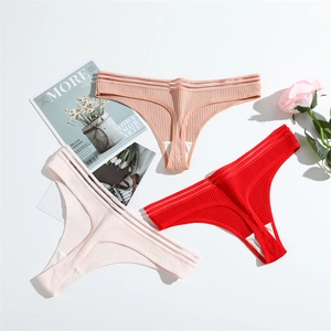Three-pack of ribbed cotton thongs in red, pink, and beige laid flat on a white surface