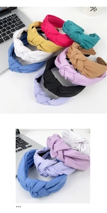 Close-up of knotted fabric headbands in various colors on a bright minimalist desk setup