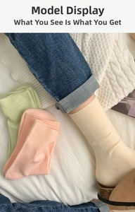 Close-up of ribbed texture and soft colors of mid-calf cotton socks in beige and pink