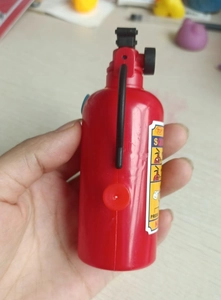 Mini red fire extinguisher water gun toy held by hand showing nozzle details
