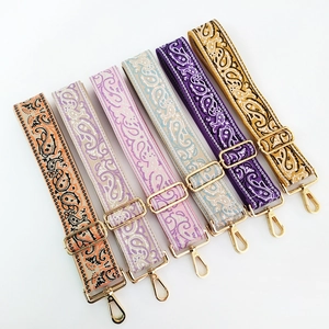 Detailed view of six colorful paisley embroidered wide purse straps with gold hardware