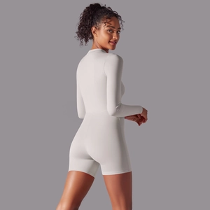 Close-up of cream long-sleeve athletic bodysuit featuring a zipper collar and ribbed fabric