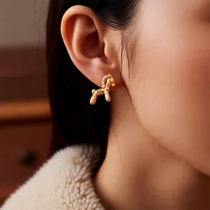18k gold plated balloon dog stud earrings with white zircon accents worn by model