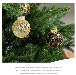 Close-up of golden diamond pattern and black sequin Christmas balls hanging on a tree