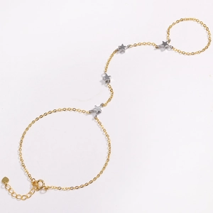 Detail of 18k gold link bracelet ring featuring silver star charms and lobster clasp