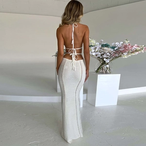 Dettaglio del top bianco a fascia e del vestito lungo traforato con schiena scoperta
