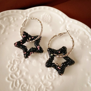Dark style hoop earrings with black sparkling star pendants and silver twist texture