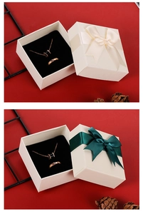 Detail view of square jewelry gift boxes with silk ribbons and black velvet inserts