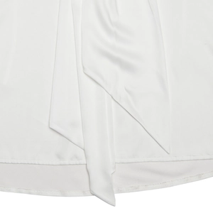Détail de l'ourlet de la robe en satin blanc avec un nœud papillon élégant