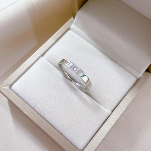 Detailed close-up of a minimalist silver titanium ring with a single small inset stone