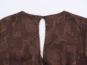 Détail de robe jacquard marron foncé avec découpe goutte d'eau et fermeture à bouton