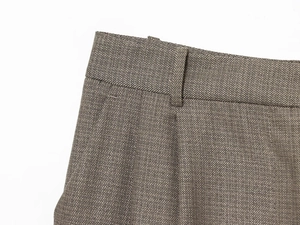 Macro shot of dark grey tailored trouser waistband with precise stitching and fabric texture