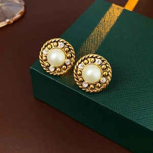 Nahaufnahme von Vintage-Ohrringen mit Perlen und Strass auf einer grünen Schmuckschatulle
