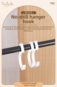 Detail of white S-shaped plastic hooks hanging on a rail for drill-free storage