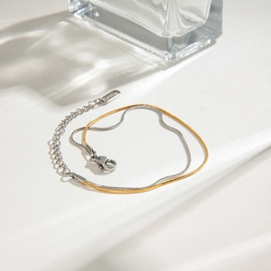 Detailed macro of two-tone gold and silver stainless steel snake chain bracelet detail