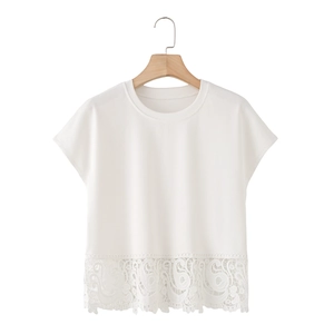 Détail de la dentelle complexe sur l'ourlet du t-shirt blanc à col rond