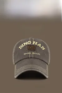 Detail of vintage washed baseball cap with DINGHAN embroidery and yellow contrast stitching