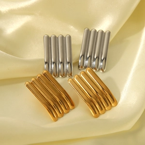 Makro-Detail geometrischer gestreifter Ohrstecker in poliertem Gold und Silberglanz