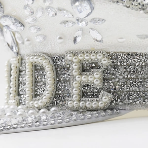 Détail d'un chapeau de capitaine blanc orné de perles, de paillettes et de strass