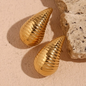 Detailed view of hollow gold-plated teardrop earrings with textured spiral design