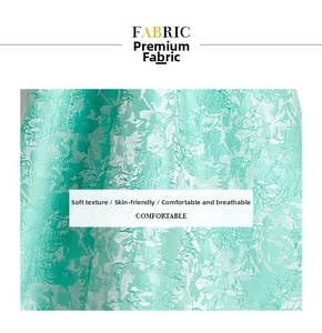 Makro-Detail von minzgrünem Jacquard-Stoff mit edlen floralen Prägetexturen