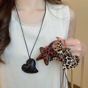 Detailed macro view of heart and star leopard print pendants with contrast stitching