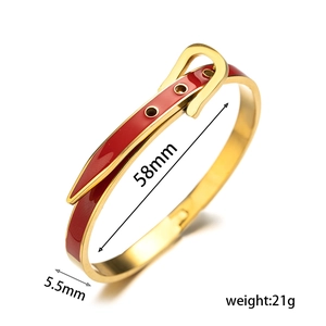 Detailed view of red enamel belt buckle style gold metal bracelet with diamond studs