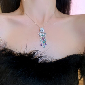 Dettaglio del ciondolo d'argento con fiore, fiocco e nappe di gemme blu-viola
