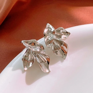 Vue détaillée des boucles d'oreilles Lys argentées avec texture plissée sur céramique