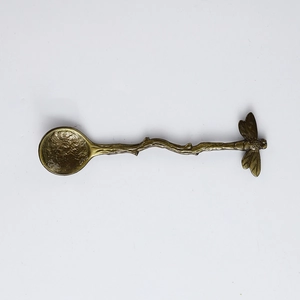 Detail of dragonfly branch handle spoon with hammer texture in vintage brass finish