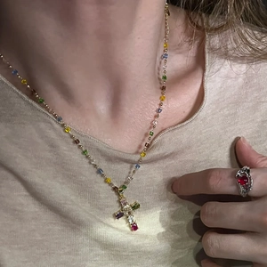 Collier en perles arc-en-ciel avec pendentif croix en pierres et une bague rubis vintage