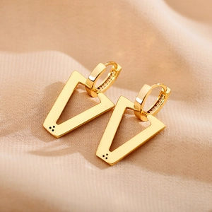 Macro view of gold V-shaped triangle earrings with pavé crystals and drop oil detail