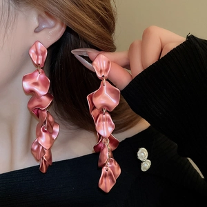 Close-up of long layered rose pink petal tassel earrings worn by a model