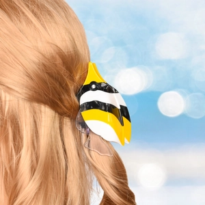 Detailed view of a tropical fish shaped acetate hair claw clip with rhinestones on blonde hair