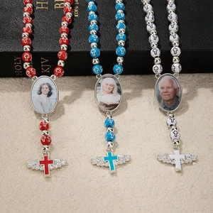 Détails de chapelets avec perles rouges bleues blanches et pendentifs croix ailée