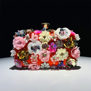 Detail of red evening clutch featuring handmade 3D floral beadwork and sequins