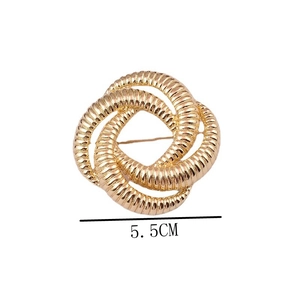 Macro view of a 5.5cm golden round knotted brooch with textured surface detail