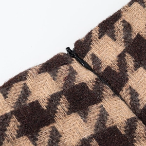 Close-up of brown houndstooth wool fabric texture with hidden zipper detail