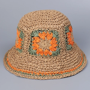 Detail of hand-woven straw hat featuring colorful floral crochet patterns and scalloped edges