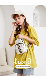 White leather chest bag detail with signature red and green stripes and gold hardware