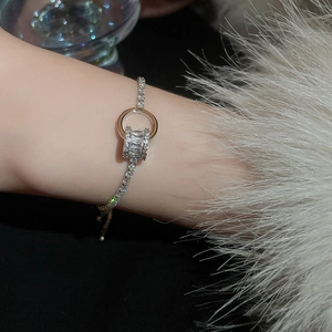 Détail macro du bracelet géométrique plaqué argent serti de zircons sur le poignet