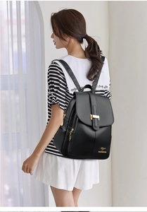 Detail of black pebbled leather backpack with gold clasp and kangaroo logo