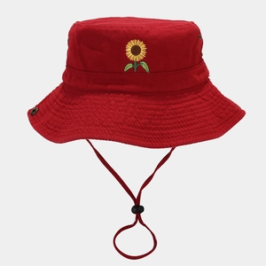 Close-up of sunflower embroidery and metal eyelets on red cotton outdoor sun hat