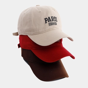 Gros plan détaillé de casquettes en coton avec broderie Paris en plusieurs couleurs