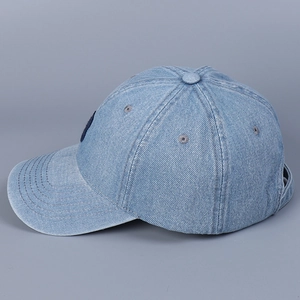 Detailed side view of light blue denim baseball cap featuring reinforced curved brim