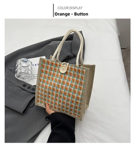 Detail of orange checkered linen handbag with rope handle and large decorative button