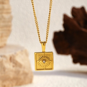 Detail of 18K gold plated square pendant with sunburst texture and sparkling crystal