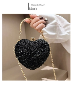 Detail of heart-shaped black rhinestone evening bag with gold circular handle and chain